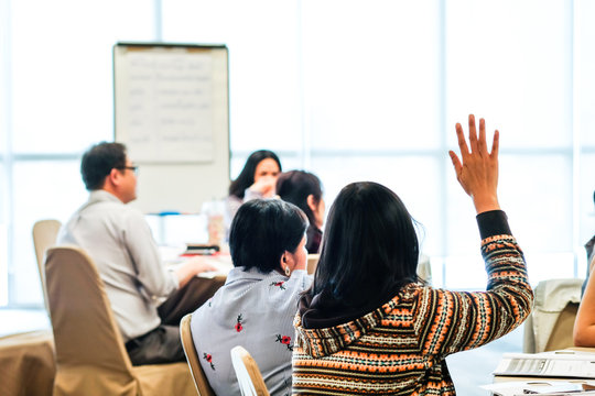 image of a female hand raised in university classroom