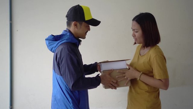 Young courier delivering the parcel boxes to the house.