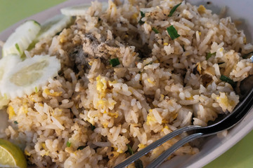 Fried rice with chicken. Prepared and served in a wok. Natural wood in the background. Top view.