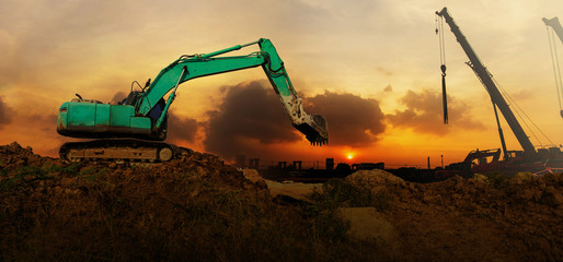 Panorama of the Excavator working on a construction site at sunset
