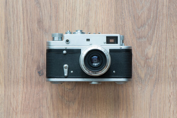 Old film rangefinder camera isolated on wooden background