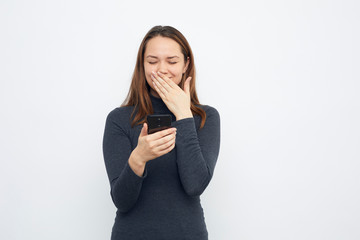 young girl giggles with cellphone in hand