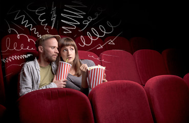 Obraz premium Young cute couple sitting in cinema, and eating popcorn while watching movie with doodle graphics