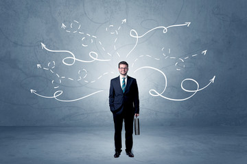 Elegant businessman choosing between directions with winding drawn arrows around 
