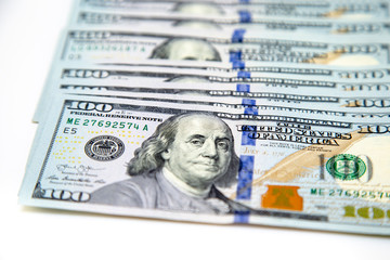 A bundle of hundred dollar bills laid out like a fan. On a white background. Background of dollar...
