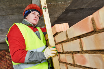 bricklayer builder worker laying bricks wall