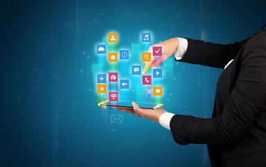 Female elegant hand holding tablet with colourful application icons