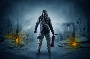 Fototapeta premium Destroyed place after a catastrophe with man in gas mask and weapon on his hand 