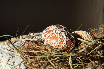 Naklejka na ściany i meble Handmade Easter Eggs decorated with lace tatting in a straw nest. Easter decoration 