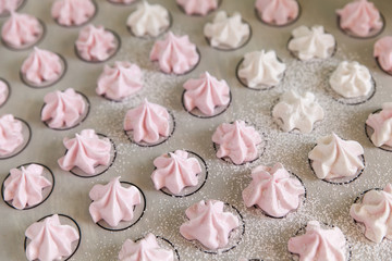 Small white and pink meringues or zephyr
