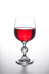 Glass of red wine on light background.