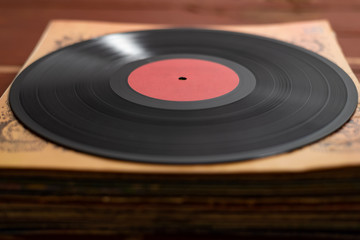 vinyl record on old red wooden background. Copy space for your label