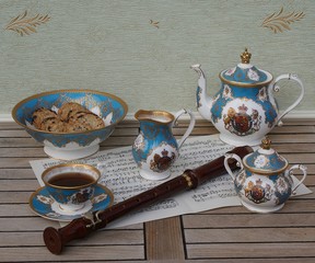 English teacup with saucer, teapot, sugar bowl, cream jug and a cake bowl with cookies, fine bone...