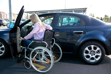 Image of young disabled woman trying to reach her car