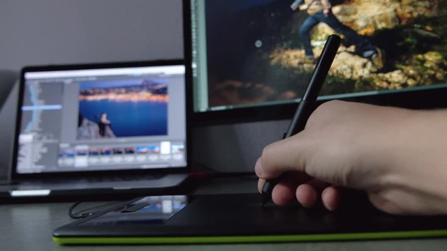 Graphic designer working with digital drawing tablet and pen on a computer