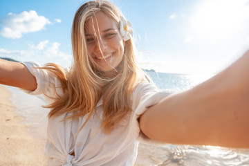 Travel vacation tourist blonde teen girl selfie photo with phone on tropical holiday.  summer vacation