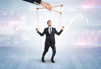 Puppet businessman controlled by another hand with financial concept
