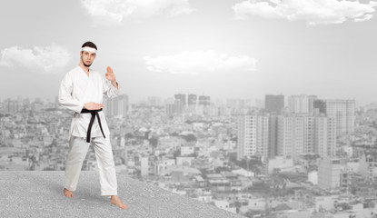 Young karate trainer doing karate tricks on the top of a metropolitan city
