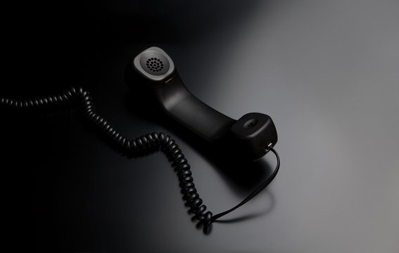 modern telephone receiver on dark back. concept technical support by phone. waiting for an answer. no answer.