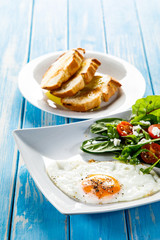 Breakfast - fried egg, toasts and vegetable salad