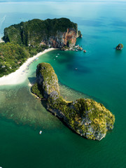 Aerial view of green rocky cliffs and boats on Phra Nang beach bay, Railay beach, in Krabi...