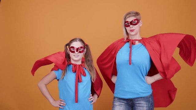 Proud mother with her young daughter imagining to be superheroes. Supermom and superdaughter ready to save the world.