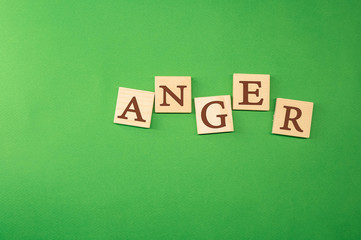 The word anger written on wooden cubes green background