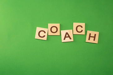 The word coach written on wooden cubes green background