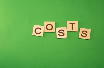 The word costs written on wooden cubes green background