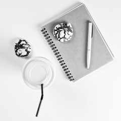Coffee, cookies, clean notebook and pen on white desk. Cozy breakfast. Mockup. Flat lay style. Business desk minimal style concept. Planning day idea. Coffee break at work.
