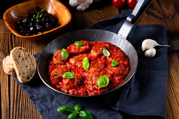 Baked mini meatballs in tomato sauce with basil