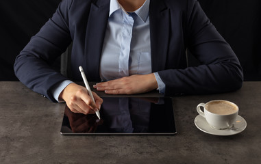 Business woman working on  tablet with dark background and copyspace
