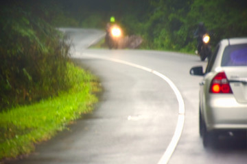 Road Trip. Back view of car on wet road in rainy day at the countryside road. Safe drive for...