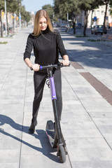 Happy woman starting an electric scooter 