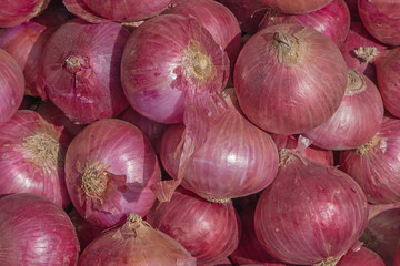 heap of red onions on market