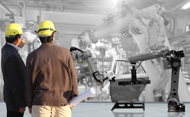 production engineer working with automate wireless Robot arm in smart factory background. Mixed...