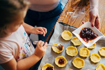Mother and daughter preparing cookies for baking