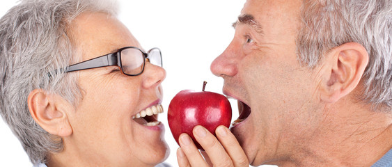 freudiges Paar beißt in roten Apfel