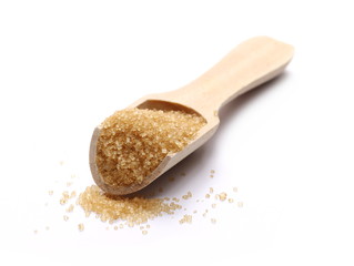 Brown cane sugar pile with wooden spoon isolated on white background and texture