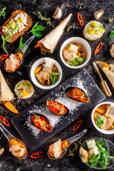 European cuisine. appetizer for wine on a black background. Pate, mini salad, canape, sea products, salmon and mussels in tomato sauce. Top view, copy space