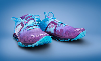 Front view of blue and purple trainers isolated on a blue background.