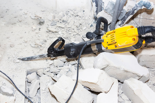 pieces of broken wall next to the jackhammer.