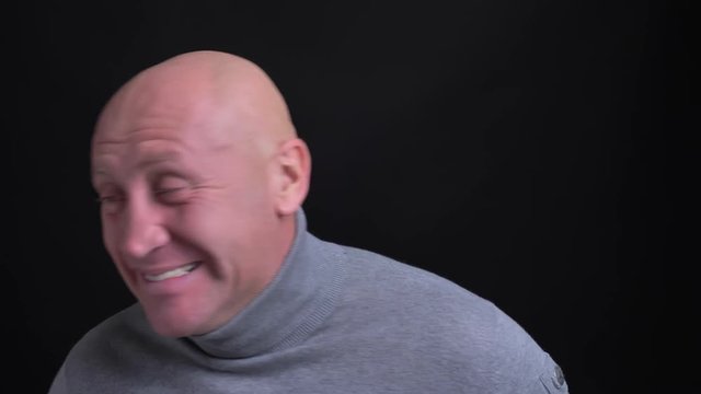 Closeup shoot of adult caucasian man literally dying of laughter being extremely excited and happy in front of the camera