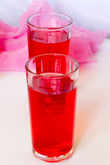 Fruit and berry red juice in glasses on a white background. Fresh and cold summer drink.