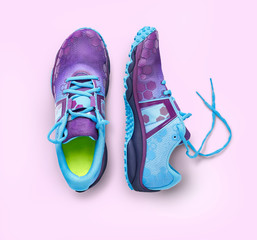 Top view of blue and purple trainers isolated on a pink background.