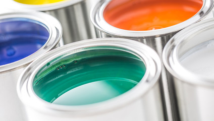 Full of multicolored paint cans on white table