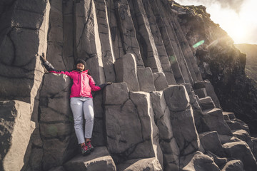 Traveler on hexagonal rocks in Vik, Iceland.