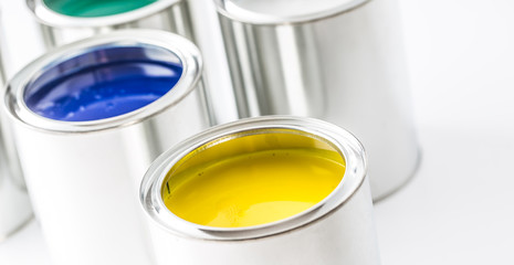 Full of multicolored paint cans on white table