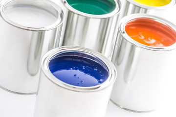 Full of multicolored paint cans on white table