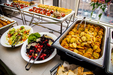 bruschetta, quiche loren mini burger with veal pastry, cheese, mustard sauce, baked potato, vinigret, chicken meat in sauce, fish, Vinigret, Caesar salad  at catering event on some festive event, part